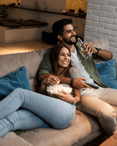 A couple cuddling on the couch in their home theatre 