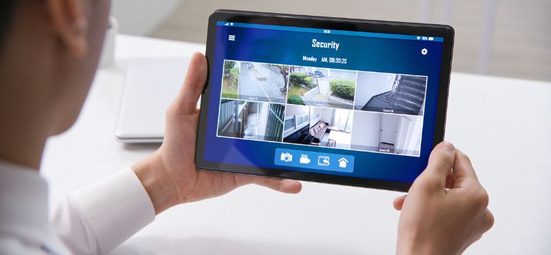 a customer holding a tablet showing security footage